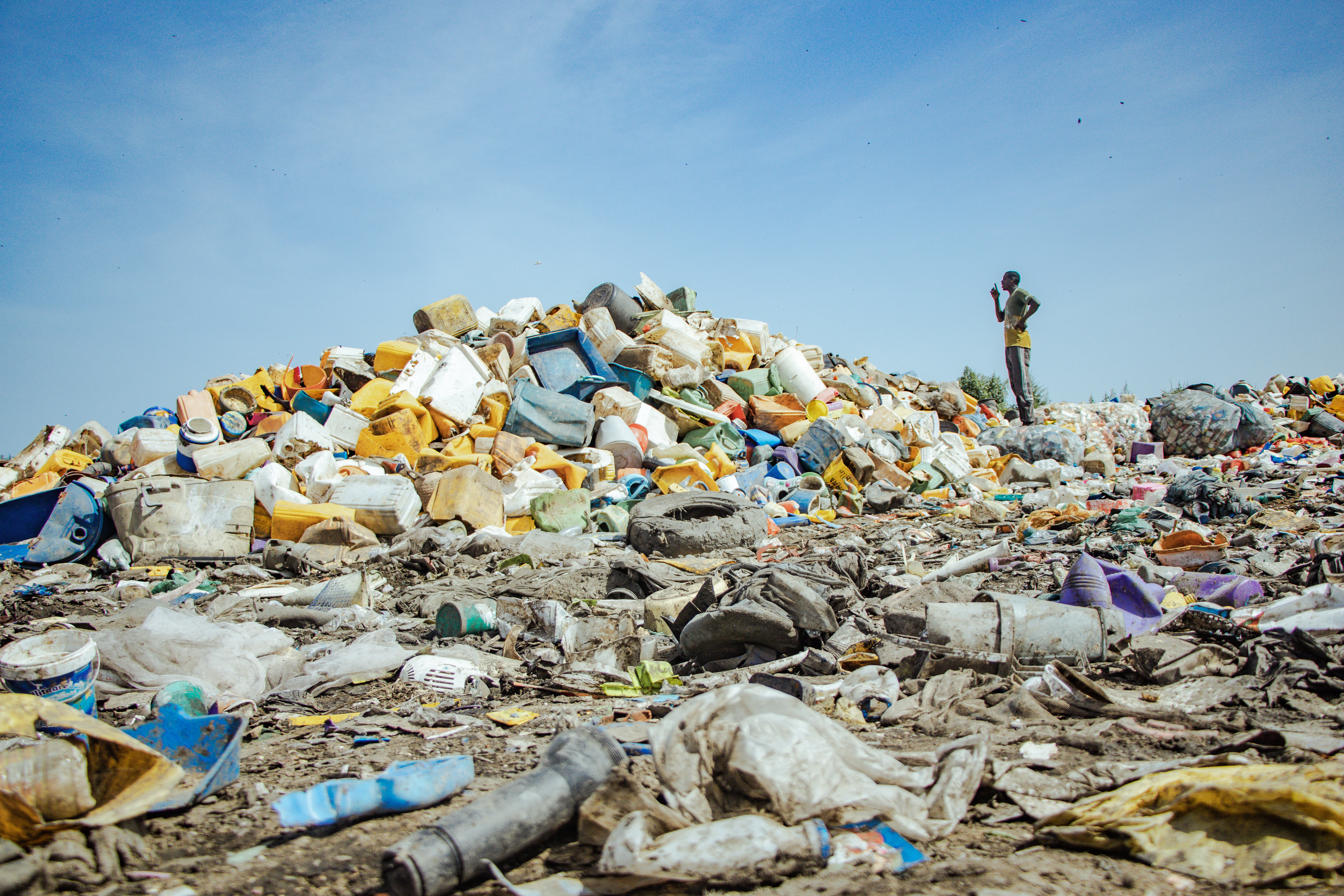 Pollution plastique Photographie d'un énorme tas de déchets plastiques, observé par un homme
