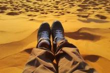 homme assis dans le sable du desert