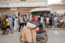 jeune homme sur un scooter transportant plusieurs sacs de pains généralement livrés en camionnette