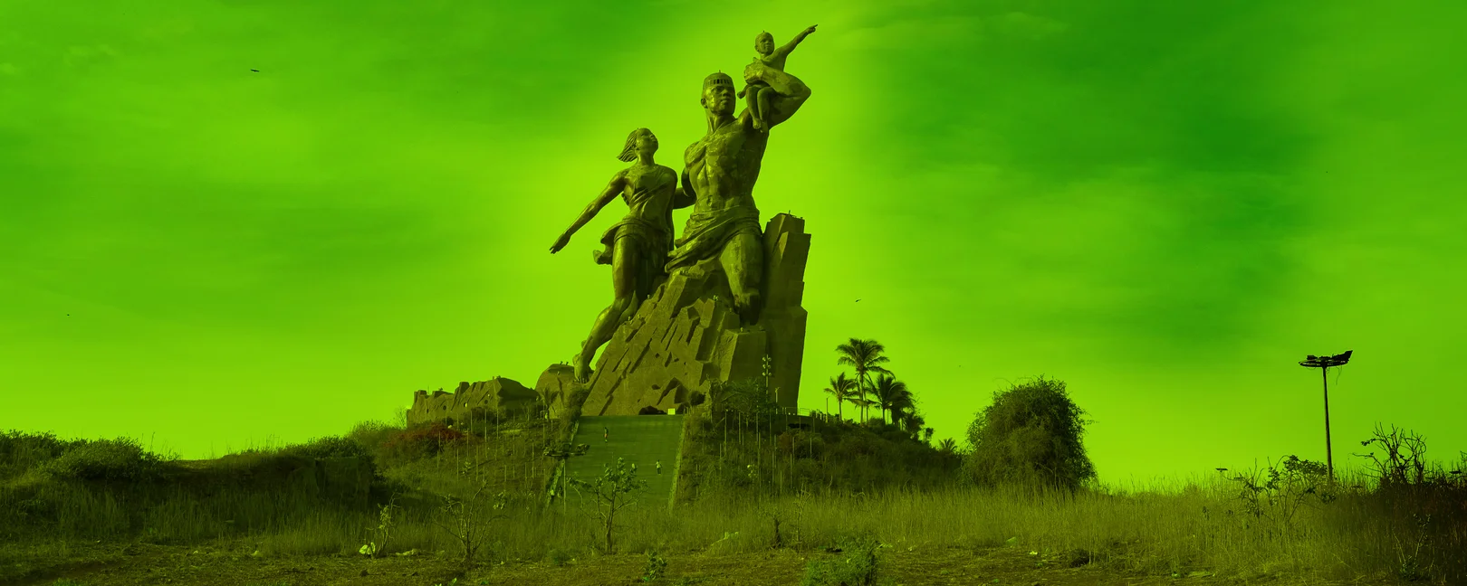 Le Monument de la Renaissance africaine à Dakar, une immense statue en bronze représentant une famille sur une colline sous un ciel clair.