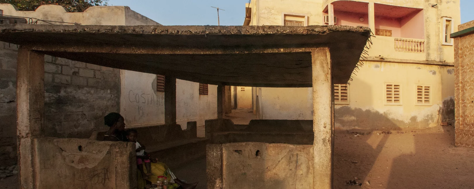 femme sous un abri dans un quartier de la banlieue dakaroise