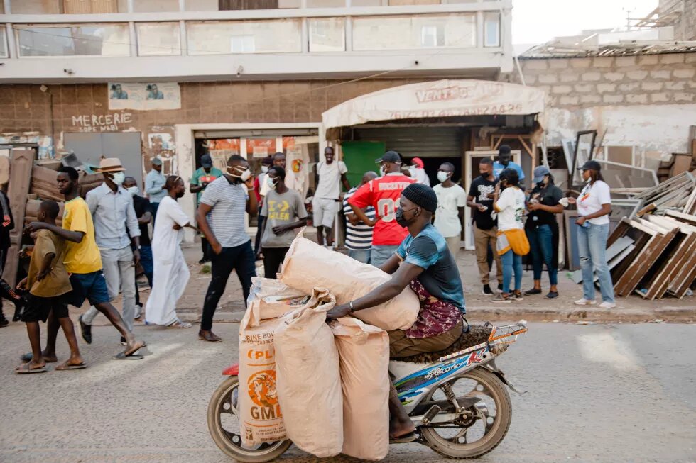 jeune homme sur un scooter transportant plusieurs sacs de pains généralement livrés en camionnette